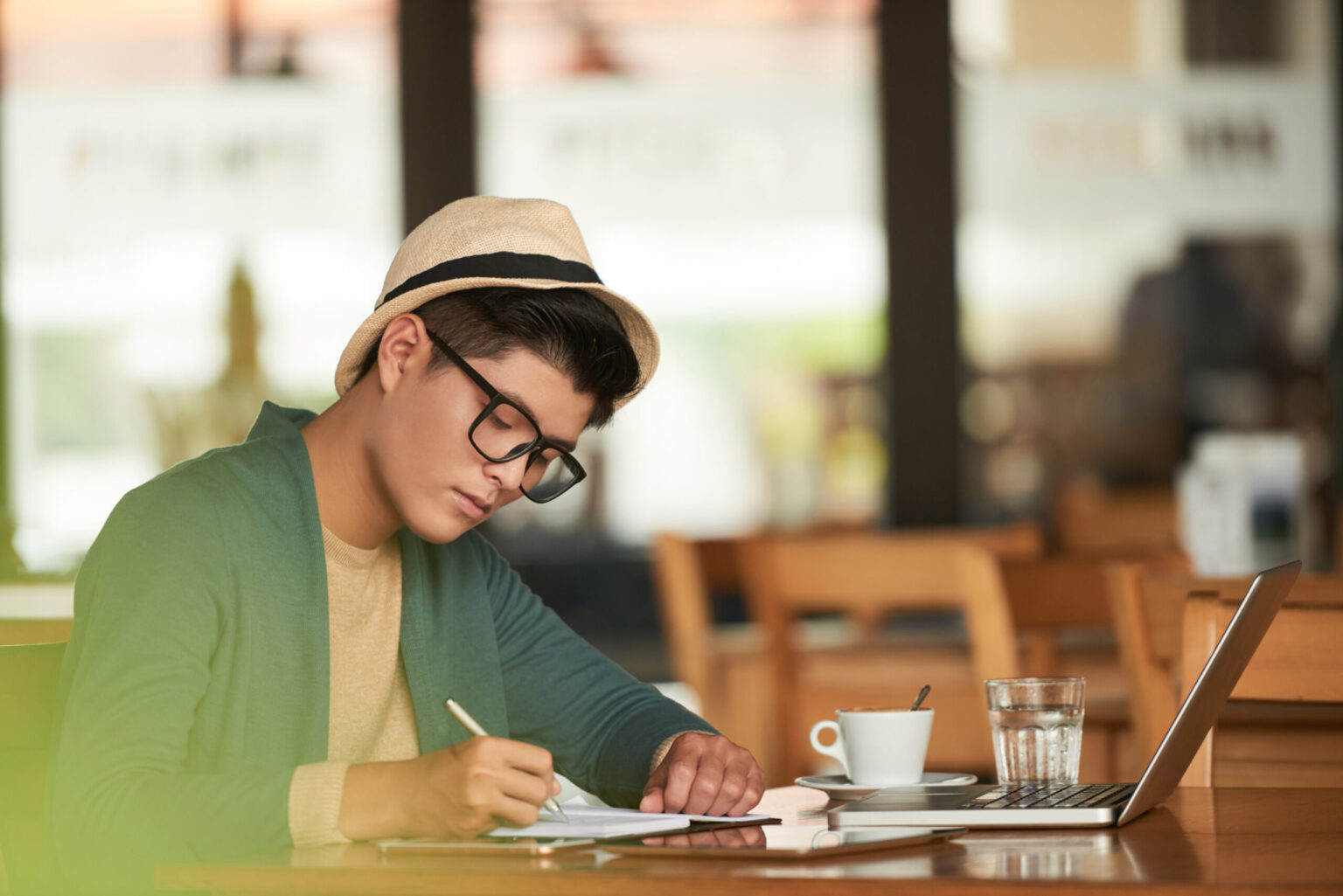 カフェでノートパソコンを使って学習する男性